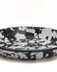 Plato hondo de peltre negro con manchas blancas y borde negro