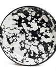 Plato hondo de peltre negro con manchas blancas y borde negro