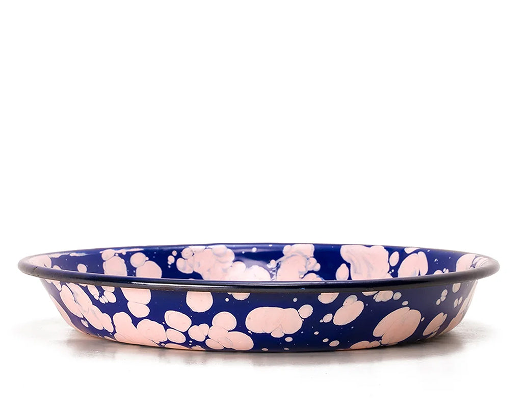 Plato hondo de peltre azul con manchas rosas y borde azul.